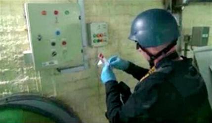 FILE - This file image made from video broadcast on Syrian State Television on Tuesday, Oct. 8, 2013, purports to show a chemical weapons expert taking samples at a chemical weapons plant at an unknown location in Syria. The Islamic State group is aggressively pursuing development of chemical weapons, setting up a branch dedicated to research and experiments with the help of scientists from Iraq, Syria and elsewhere in the region, according to Iraqi and U.S. intelligence officials. (Syrian State Television via AP video, File)