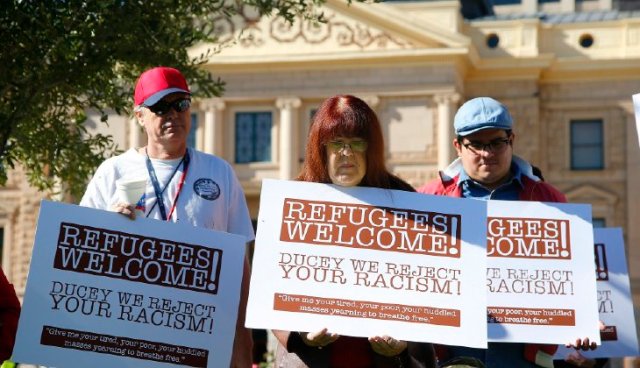 Supporters for the welcoming of Syrian refugees pause during a rally at the Arizona Capitol Tuesday, Nov. 17, 2015, in Phoenix. Arizona Gov. Doug Ducey has joined a growing number of governors calling for an immediate halt to the placement of any new refugees in the wake of terrorist attacks in Paris. The U.S. State Department says Arizona has received 153 Syrian refugees so far this year. (AP Photo/Ross D. Franklin)