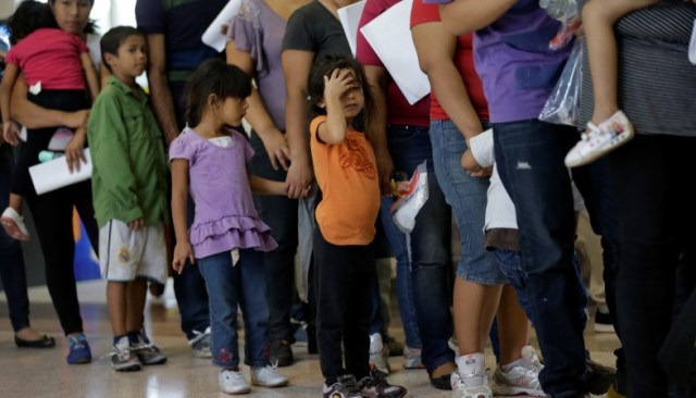 In this June 20, 2014 photo, immigrants who entered the U.S. illegally stand in line for tickets at the bus station after they were released from a U.S. Customs and Border Protection processing facility in McAllen, Texas. The immigrants entered the country through an area referred to as zone nine. (AP Photo/Eric Gay)